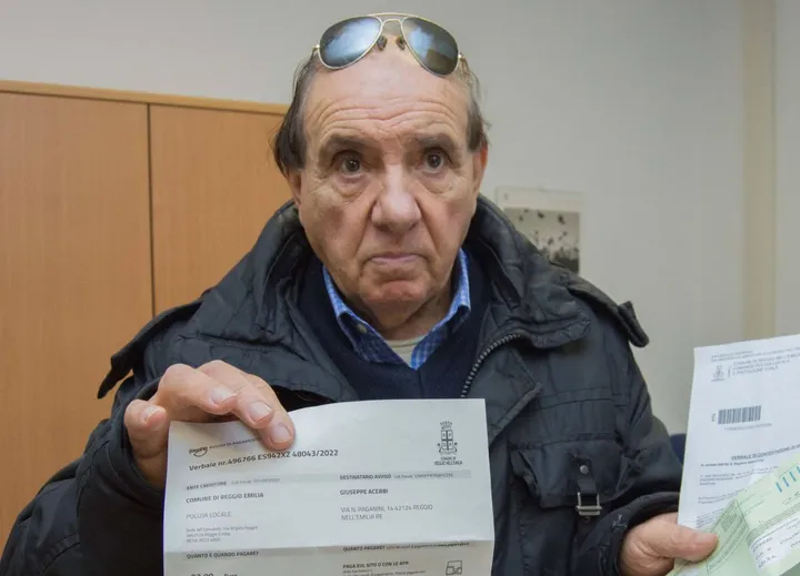 Giuseppe Acerbi, 75 anni, mostra i verbali ricevuti in via Leoncavallo