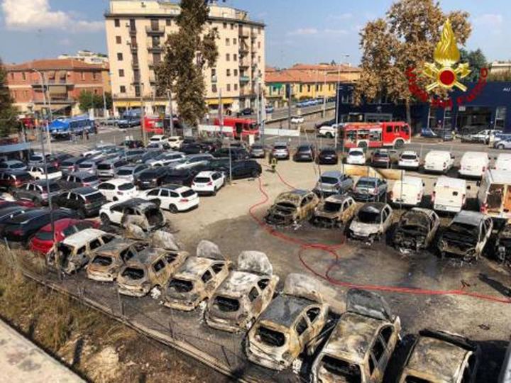 Le carcasse di auto bruciate (foto Ansa)