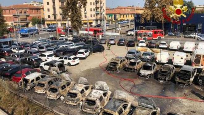 Le carcasse di auto bruciate (foto Ansa)