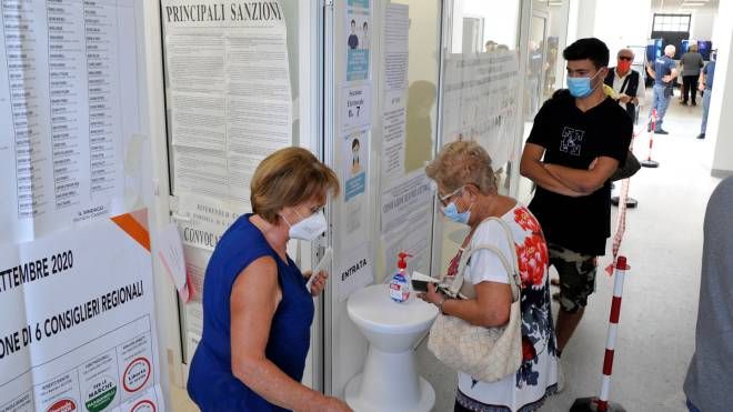 L'igienizzazione prima di entrare ai seggi (foto Calavita)