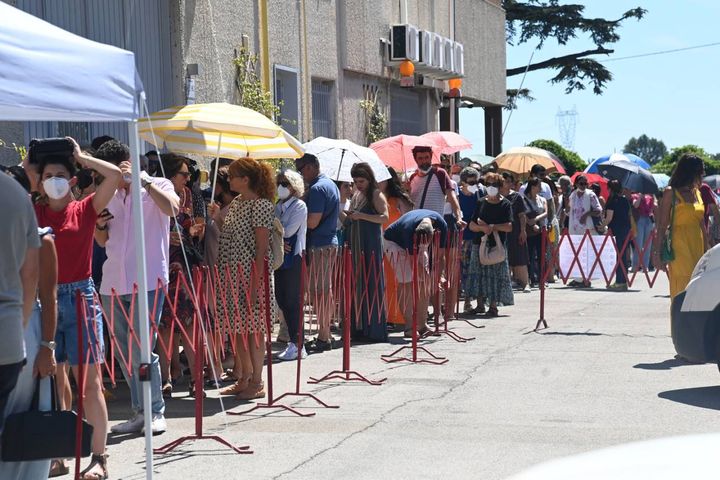 In fila con gli ombrelli per ripararsi dal sole (FotoSchicchi)