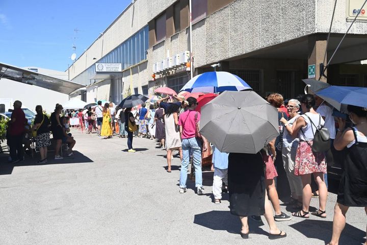 In fila con gli ombrelli per ripararsi dal sole (FotoSchicchi)