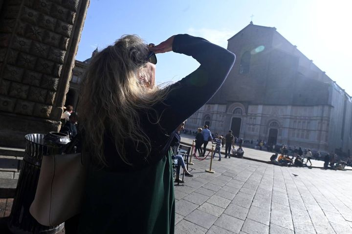 Bologna si ferma con il naso insù per l'eclissi di sole (foto Schicchi)