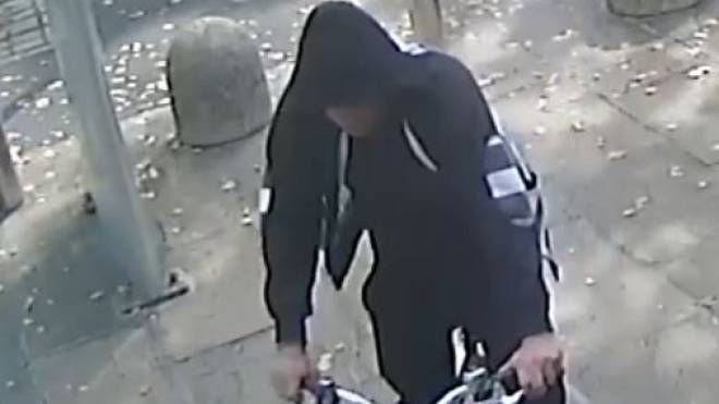 Il rapinatore ripreso dalle telecamere mentre fugge in bici