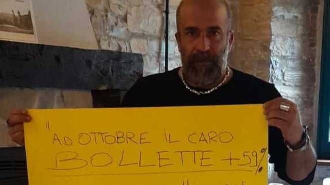 Maurizio Pace mostra un cartello di protesta nel suo ristorante Cà Poggioli. 