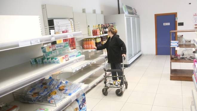 L’ultima spesa dei clienti negli scaffali svuotati al supermercato